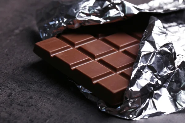 Čokolády v alobalu na šedém pozadí — Stock fotografie