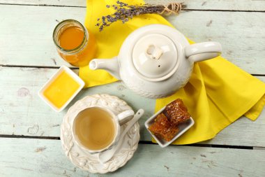 Petek, tatlım, çaydanlık renk ahşap arka plan üzerine bir kase