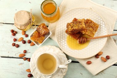 Petek, tatlım, renk ahşap arka plan üzerinde bitkisel çay bardağı ile kase