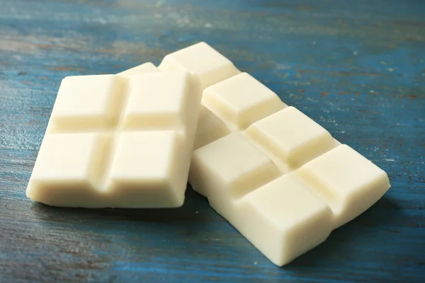 Witte chocolade stukjes op een houten achtergrond kleur — Stockfoto