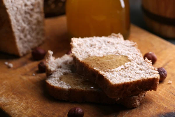 Pão fresco com mel no fundo de madeira — Fotografia de Stock