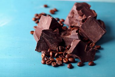 Siyah çikolata parçaları ve renk ahşap arka plan üzerinde kahve taneleri