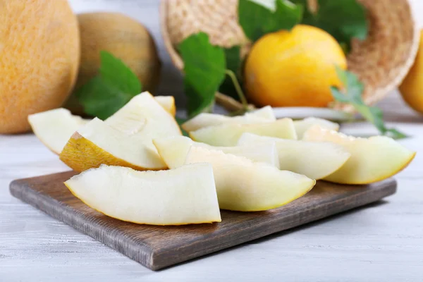 Slices of ripe melons with green leaves — Stock Photo, Image