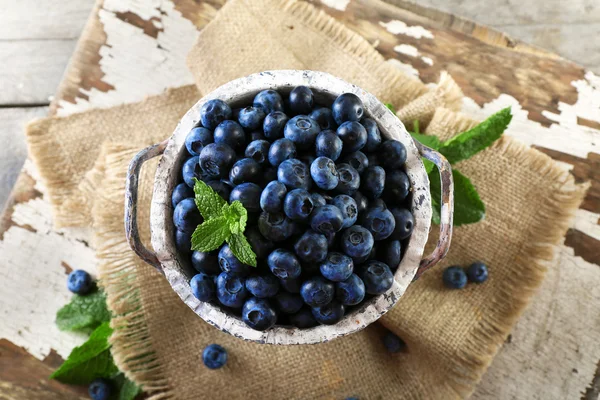 Ripe blueberries with leaves in bucket — Stock Photo, Image