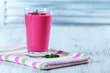 Ahşap arka plan üzerinde çilek ile Ahududu milkshake bardak