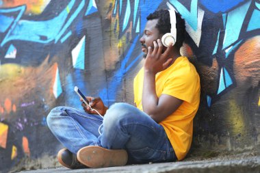 Graffiti duvar arka plan üzerinde kulaklık ile Afrika kökenli Amerikalı adam