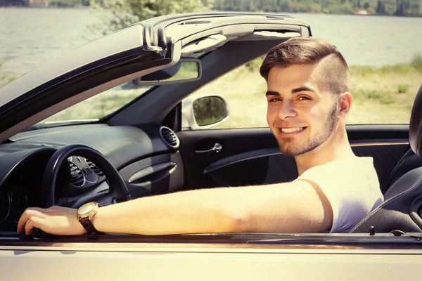 Jonge man in cabriolet, buitenshuis — Stockfoto