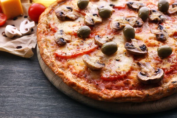 Pizza saborosa com legumes e queijo na mesa de perto — Fotografia de Stock