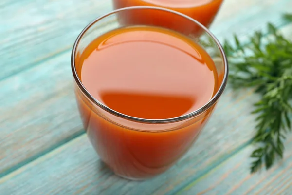 Vasos de jugo de zanahoria sobre fondo de madera — Foto de Stock