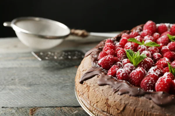 Kuchen mit Schokoglasur und Himbeeren auf Tablett auf dunklem Hintergrund — Stockfoto