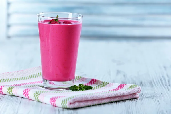 Glass of raspberry milk shake with berries on wooden background — Stock Photo, Image