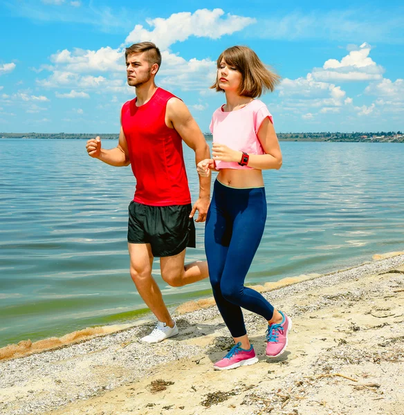 Unga människor jogging på stranden — Stockfoto