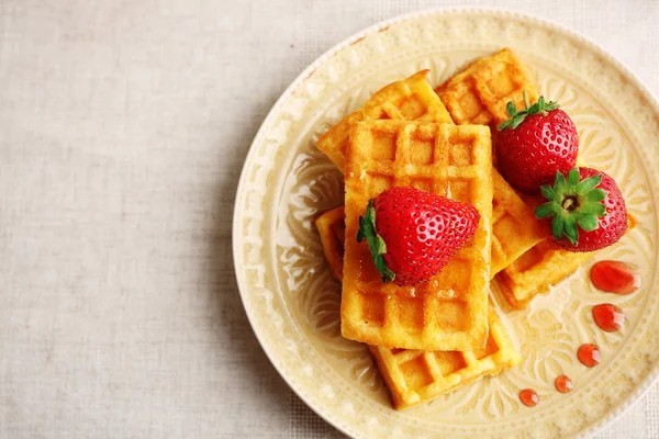 Süße hausgemachte Waffeln mit frischen Erdbeeren auf Teller, auf hellem Hintergrund — Stockfoto