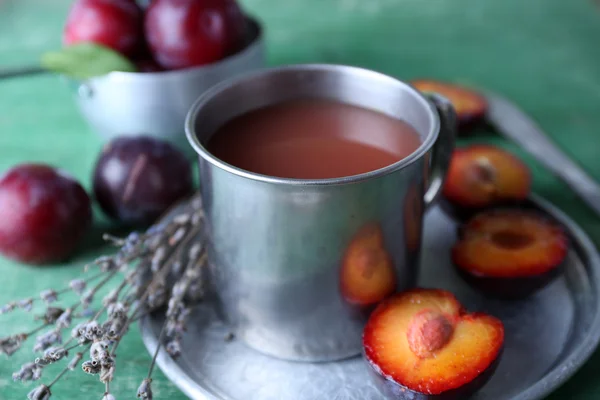 Läckra plommon juice med frukter på träbord nära håll — Stockfoto