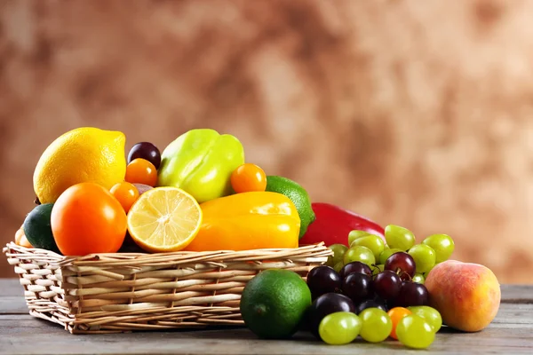 Un mucchio di frutta e verdura fresca nel cesto sul tavolo di legno da vicino — Foto Stock