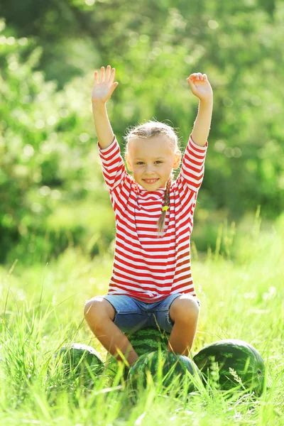 Klein meisje met watermeloenen op gazon — Stockfoto