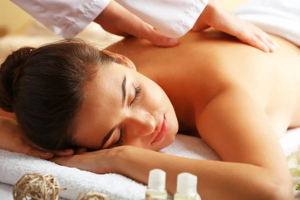 Ung kvinna på massagebänk i spa skönhetssalong — Stockfoto