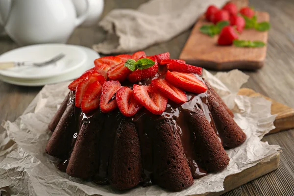 Delicioso bolo de chocolate com bagas em prato na mesa, close-up — Fotografia de Stock