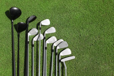 Üst üste bir yeşil çimenlerin üzerinde farklı golf kulüpleri