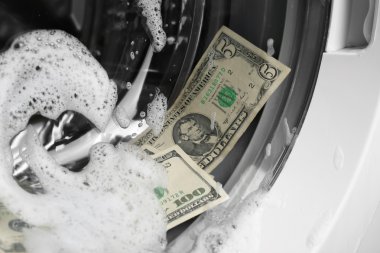 Laundering of dirty money in washing machine, close up clipart