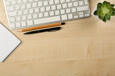Beyaz klavye ve masanın üstünde defter