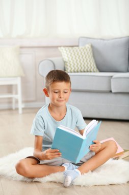 Halı, eve iç arka plan üzerinde oturup kitap ile küçük çocuk