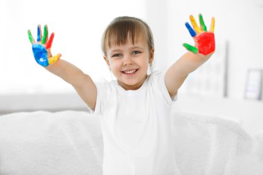 Boya, eve iç arka plan üzerinde elleriyle küçük kız