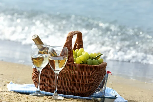 Panier pique-nique avec bouteille de vin sur la plage de sable — Photo