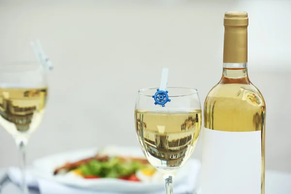 Bottle of luxury wine with tasty salad on white served table