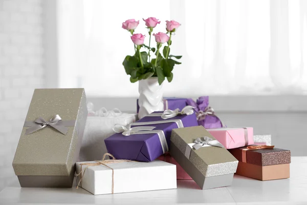 Composition of cute gift boxes and roses on white table — Stock Photo, Image