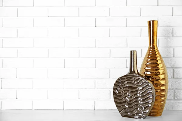 Beautiful vases on brick wall background — Stock Photo, Image