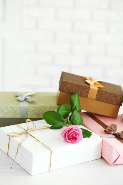 Carino scatole regalo con rosa sul tavolo, primo piano — Foto Stock