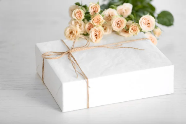 Caixa de presente branca grande com buquê de rosas na mesa — Fotografia de Stock