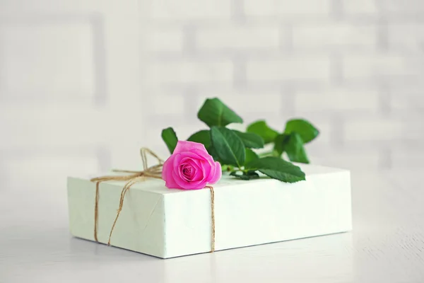 Big white gift box with rose on the table, close up — Stock Photo, Image