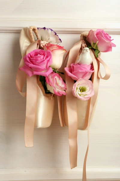 Beautiful ballet shoes with roses in it hanging on white frame background, close up — Stock Photo, Image