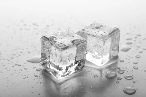Olvadó jég-kocka, szürke háttér — Stock Fotó