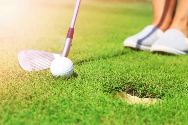 Golfer met club rollen tot een bal naar de cup op luxe golfbaan — Stockfoto