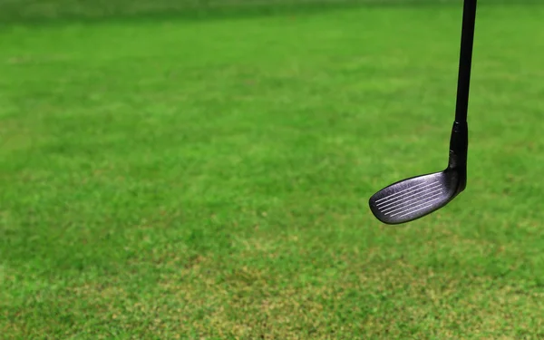 Дорогостоящий гольф-клуб на зеленом поле для гольфа, крупным планом — стоковое фото