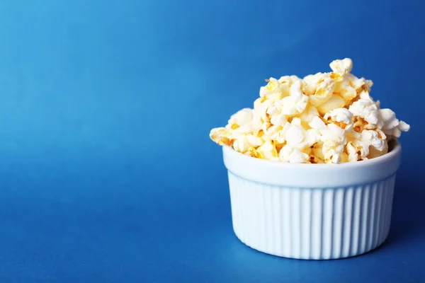 Salted popcorn on blue background — Stock Photo, Image