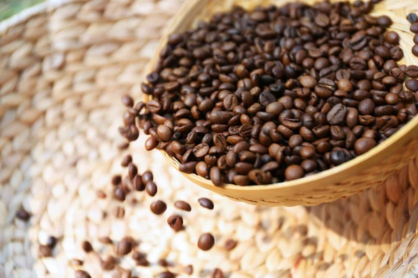 Granos de café tostados se dispersan de la cesta de wattled en el otro — Foto de Stock