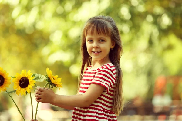 Ayçiçeği ile küçük kız — Stok fotoğraf