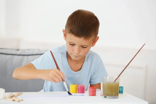 Το χαριτωμένο μικρό αγόρι ζωγραφική εικόνα σε σπίτι εσωτερικό φόντο — Φωτογραφία Αρχείου