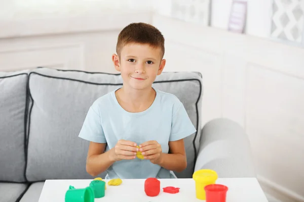 Lindo niño moldes de plastilina en la mesa — Foto de Stock