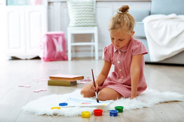 Kleines Mädchen zeichnet im Zimmer — Stockfoto