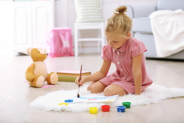 Kleines Mädchen zeichnet im Zimmer — Stockfoto