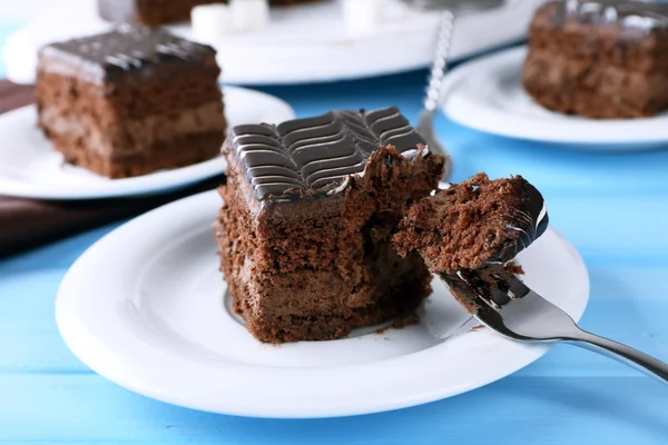 Table servie avec gâteau au chocolat sur fond bleu close-up — Photo
