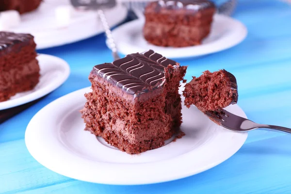 Servito tavolo con torta al cioccolato su sfondo blu primo piano — Foto Stock