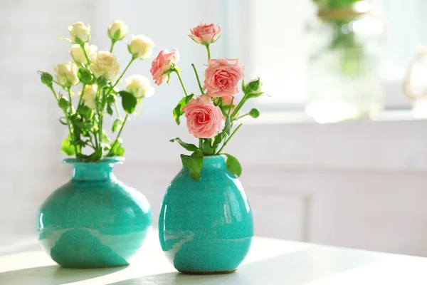 Hermosas rosas en jarrones turquesa en el fondo de la ventana — Foto de Stock