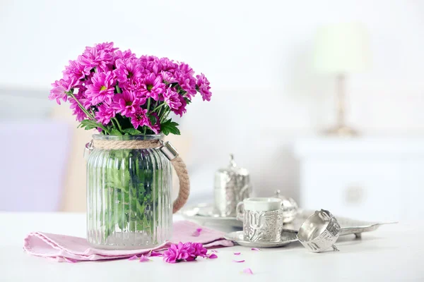 Piękne kwiaty w wazonie na stole w pokoju — Zdjęcie stockowe