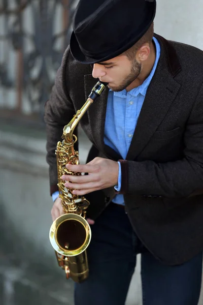Tuğla duvarın yanında dışında saksofon adamla — Stok fotoğraf